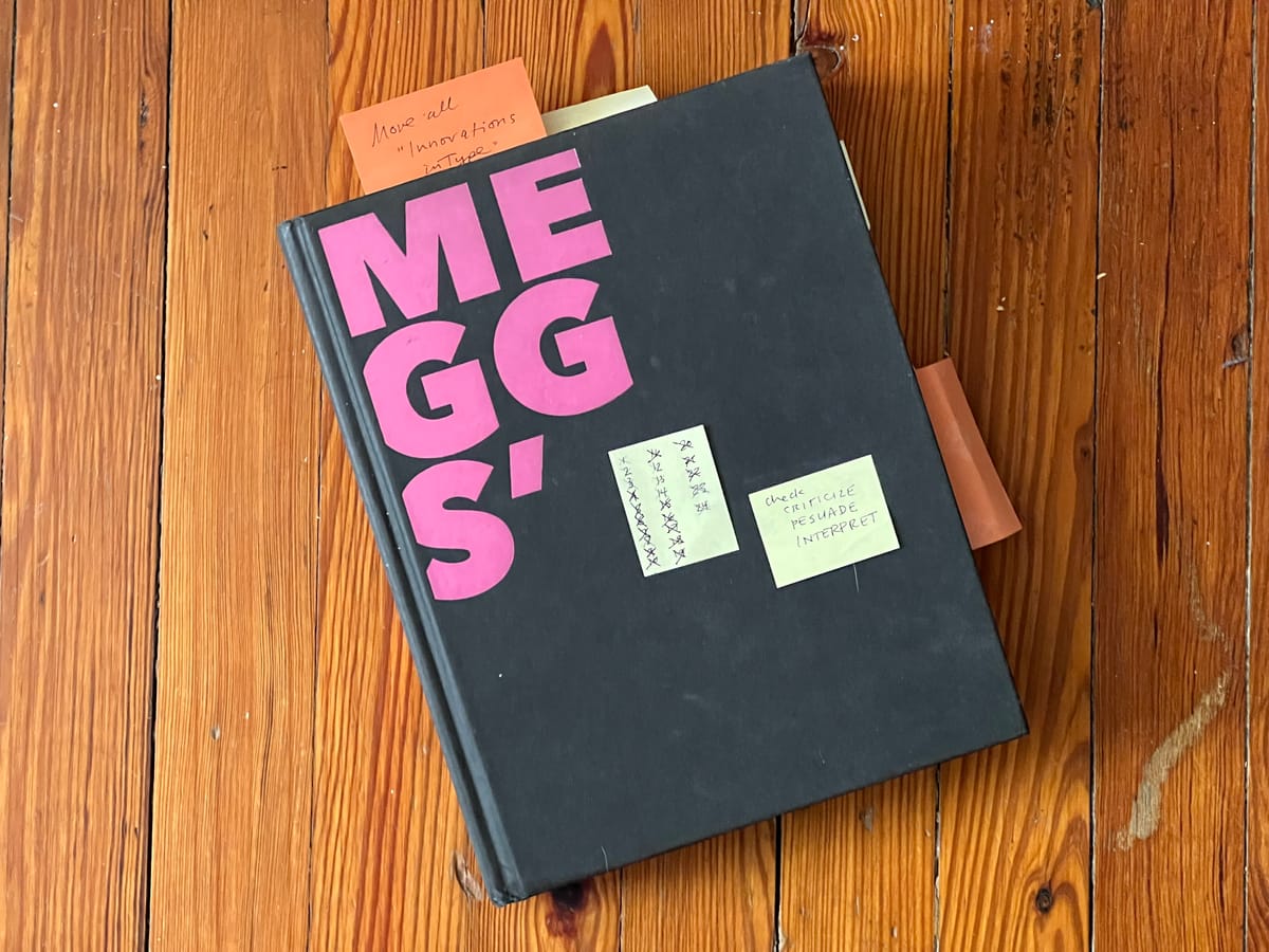 book without dust jacket featuring large capital letters spelling MEGGS' with editorial notes stuck on top and inside book 